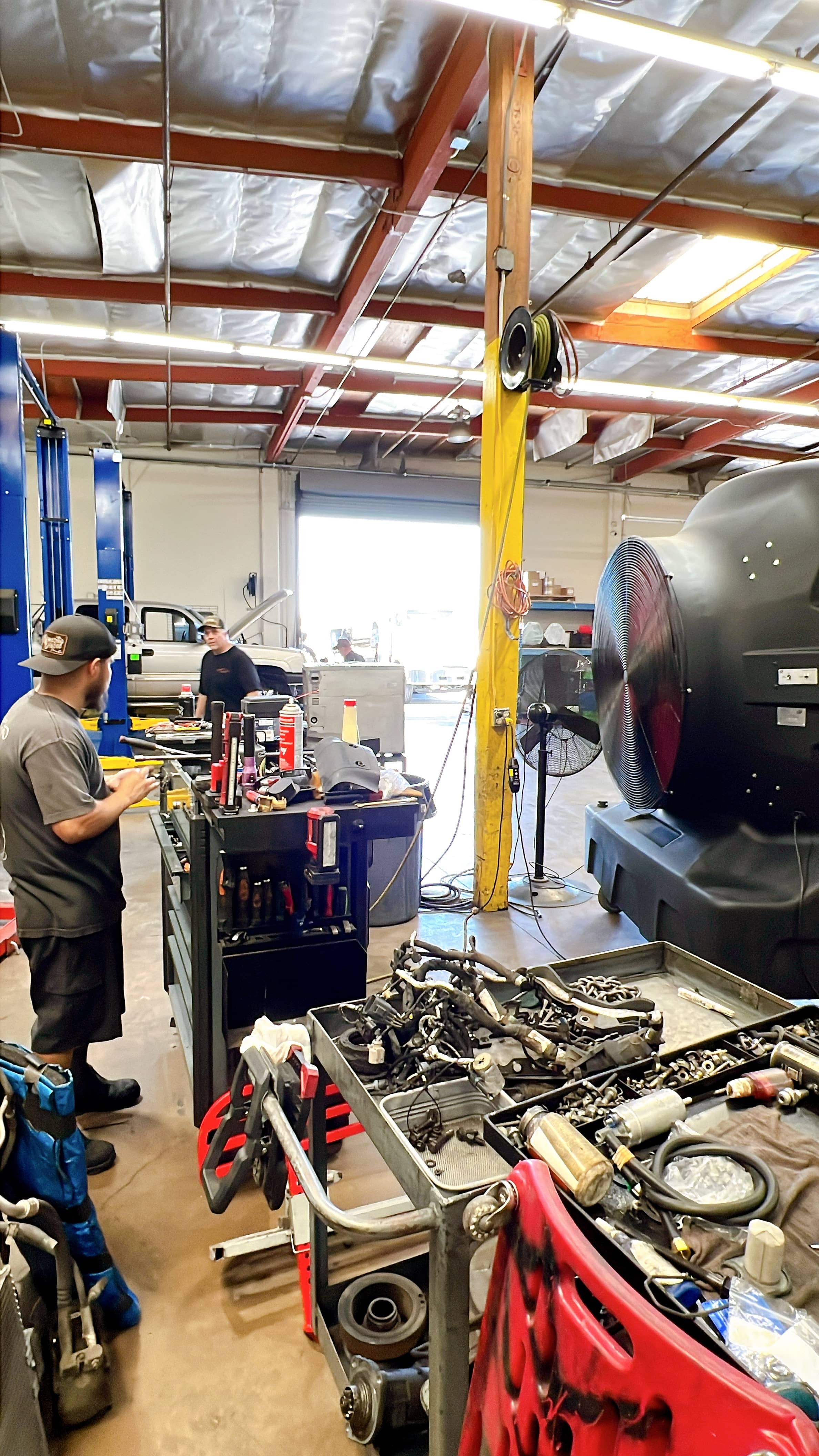 SB Evaps Evaporative Cooler in a Auto Shop center with a man using different tools