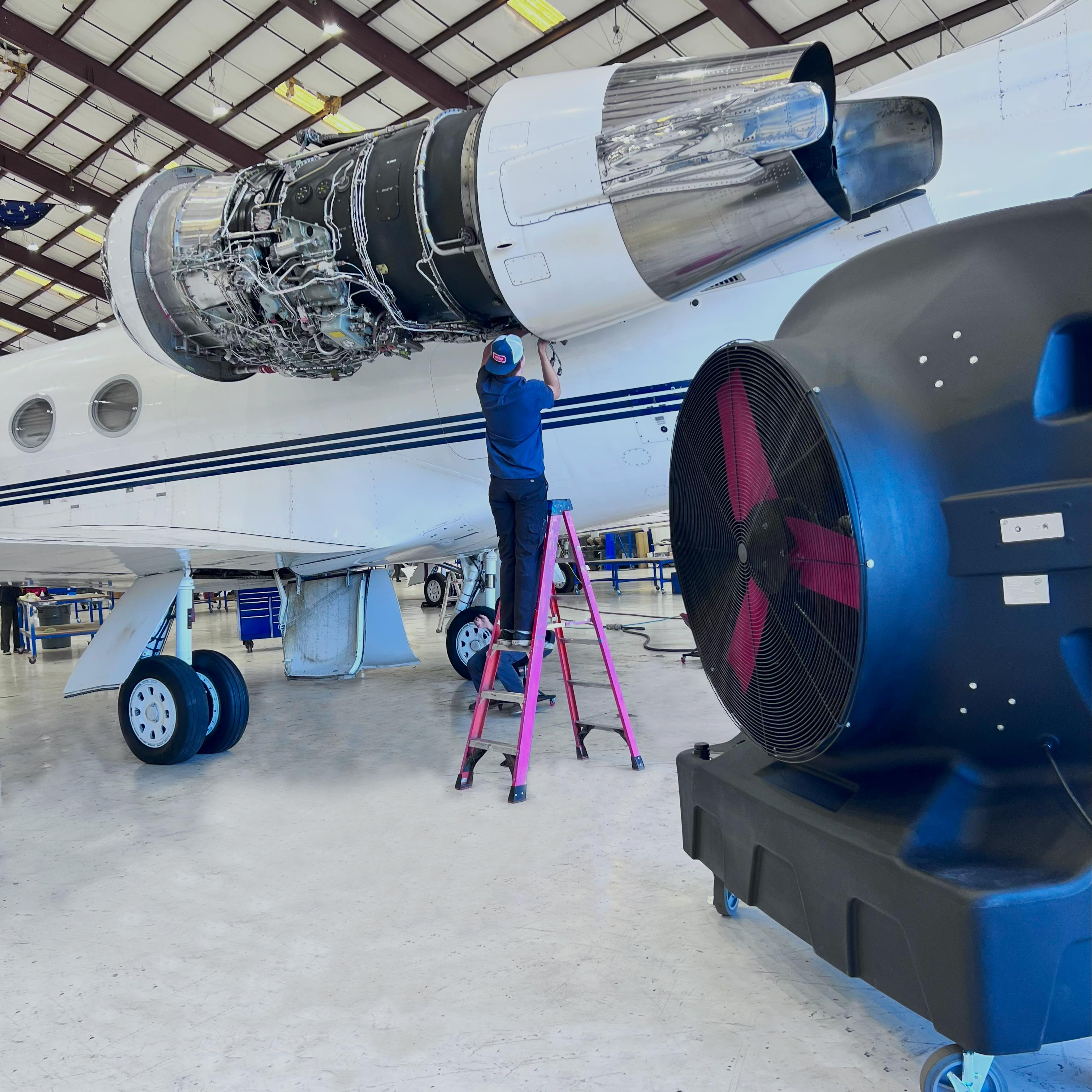 SB Evaps Evaporative Cooler in a Aviation center with a man fixing and air plane